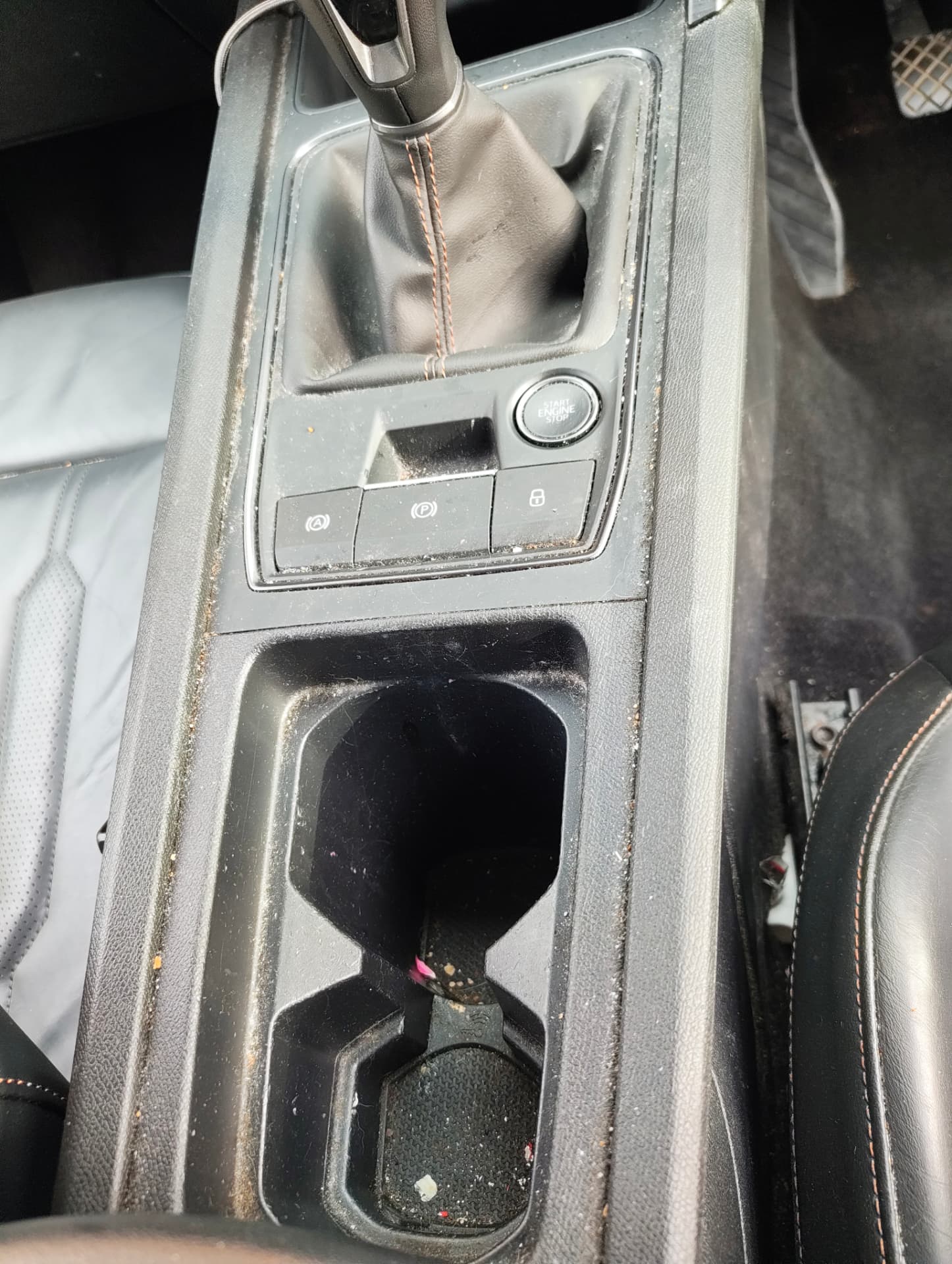 Cupra centre console and cup holders with debris before cleaning