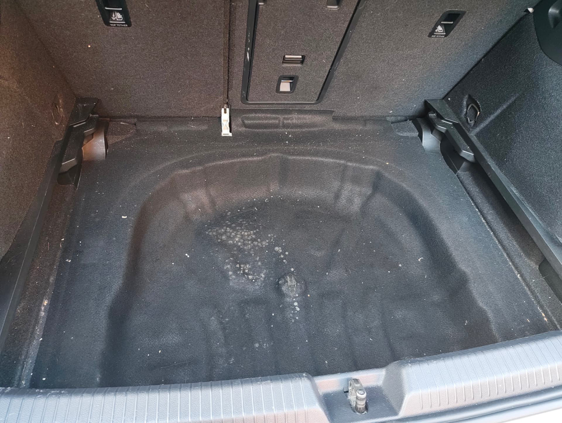 Golf spare wheel well with grit and stains before cleaning