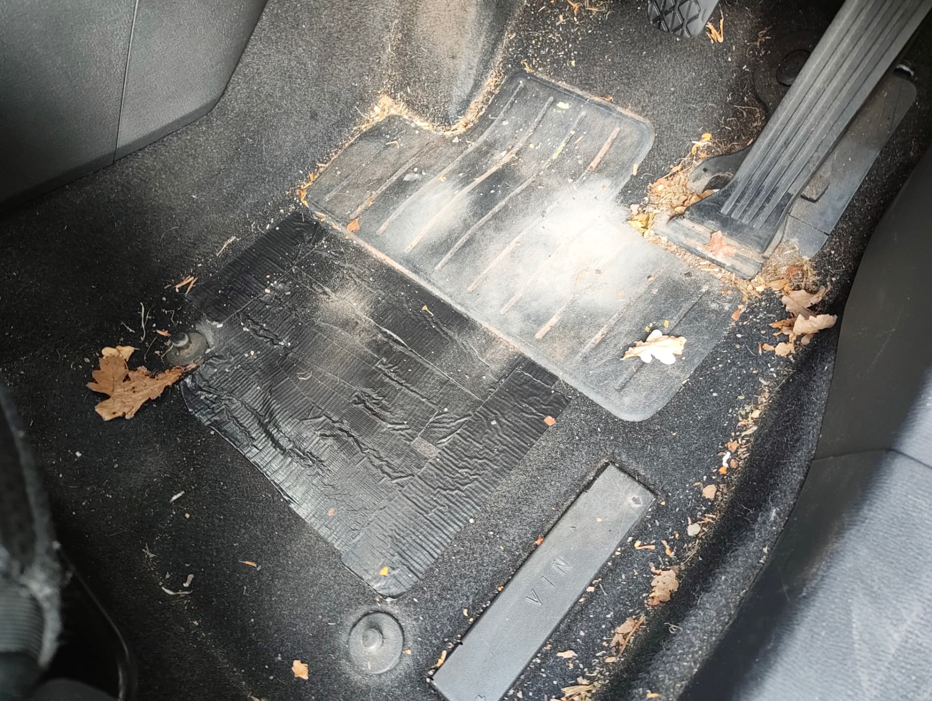 Seat rail area with trapped debris before steam cleaning